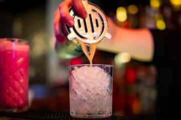 woman hand bartender making cocktail in glass on the bar counter