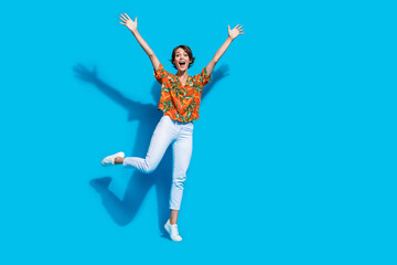 Full body portrait of astonished overjoyed lady raise arms empty space isolated on blue color background