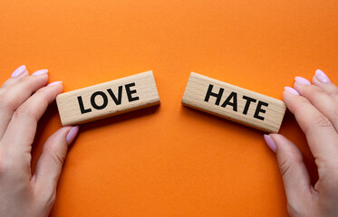 Love vs Hate symbol. Concept word Love vs Hate on wooden blocks. Businessman hand. Beautiful orange background. Business and Love vs Hate concept. Copy space