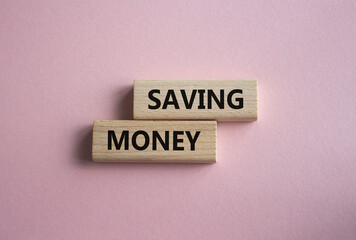 Saving Money symbol. Concept word Saving Money on wooden blocks. Beautiful pink background. Business and Saving Money concept. Copy space