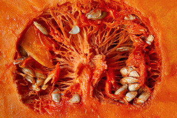 Cut pumpkin. Pumpkin texture. Pumpkin seeds close up. Orange vegetable. Diet food concept. Vegetarian food