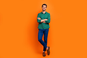 Full body cadre of brunet businessman manager administrator folded hands posing student team building isolated on orange color background