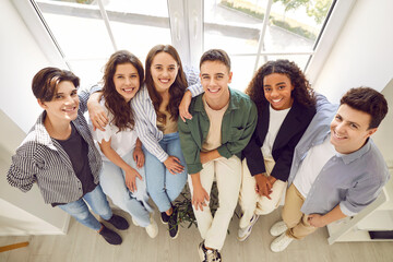 Top view of a group of happy smiling friends high school students standing together and looking...