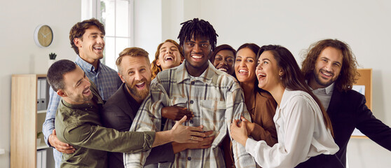 Happy diverse business team celebrating colleague's success together. Group portrait of cheerful...