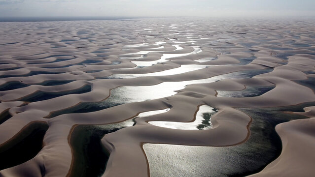Sunset at sand dunes and rain water lagoons at northeast brazilian paradise. World travel destinations. Tropical scenery. Lencois Maranhenses Maranhao Brazil. 