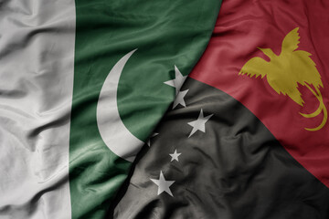 big waving realistic national colorful flag of pakistan and national flag of Papua New Guinea .