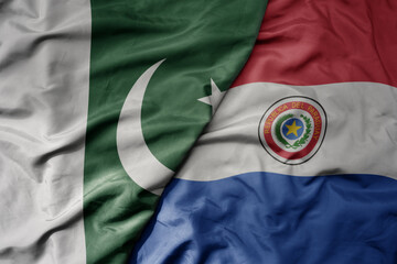 big waving realistic national colorful flag of pakistan and national flag of paraguay .