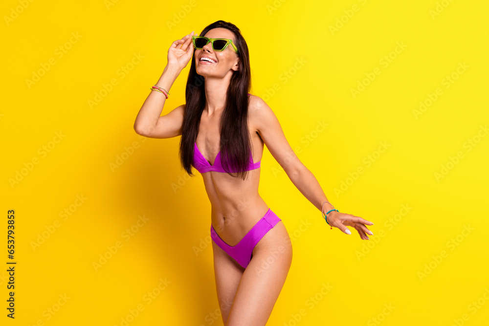 Wall mural Photo of lovely cheerful carefree person hand touch sunglass enjoy summer time isolated on yellow color background