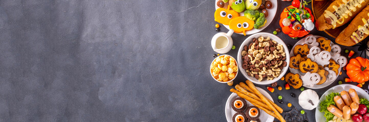 Halloween monster food and snack assortment. Set of funny creative food for children Halloween party, children brunch or breakfast - cookies, healthy and fast food snacks, breakfast cereals, hot dogs