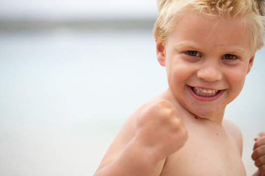 little boy flexing his muscles and clenching his fists