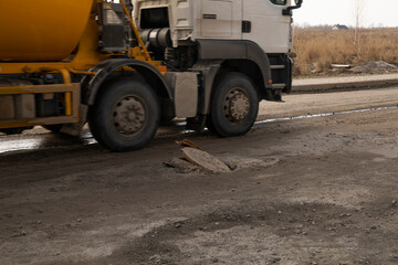 A broken road with open sewer hatch. Danger to cars and pedestrians.