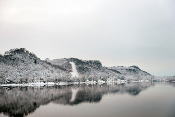 Snow covered trees lining Mississippi River in Winter