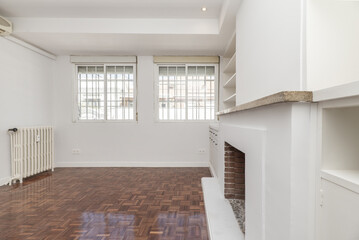 Living room in apartment with built-in fireplace, metal bars on the windows and matching white...