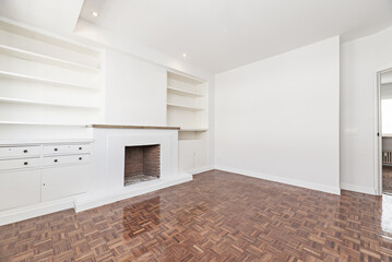 Living room in apartment with built-in fireplace, bright reddish parquet floors, halogen spotlights...