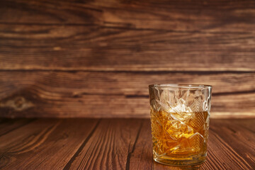 a cut crystal glass on a dark brown wooden surface