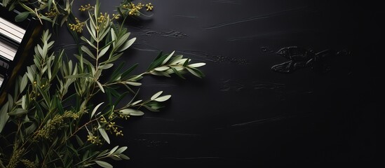 Top view of religious music on a black table adorned with olive branches and a Christian cross for Palm Sunday