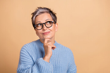 Photo portrait of cute grandmother touch chin look empty space dressed stylish blue knitted garment...
