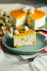 Mango Yogurt Cake slice topping with pistachio fork and flowers served in plate isolated on napkin side view cafe bake food