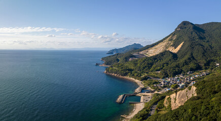Panoramic aerial view of mountain strip mines by coastal town and harbor