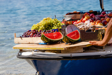 Watermelons, green and purple grapes, peaches in a boat in Brela, Croatia