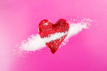 Red blood splatter in form of a heart mixed with sugar crystals on magenta background, soft focus close up, diabetes concept