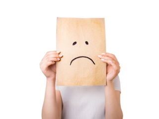 young woman hiding her face behind a sheet of paper with a sad smiley face drawn on the sheet, fake emotions