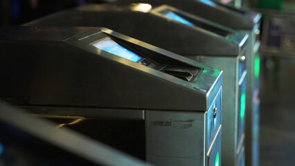 Close up of turnstiles with contactless pass card space at night on the tram metro station. 