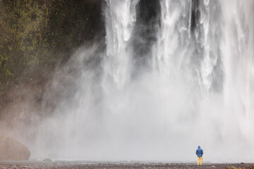 Person at the foot of Skógafoss, Suðurland, Iceland