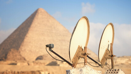 Satellite dishes against the background of The Great pyramid of Giza. Ancient mystic contact with...