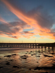Fototapeta na wymiar Beautiful sunset with the pier in the background in Cayucos, California, USA.