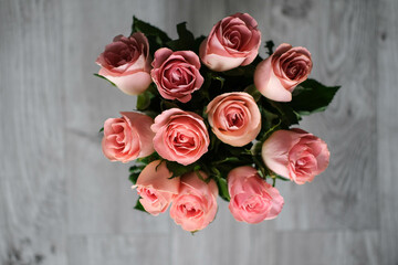 bouquet of pink roses in a vase on a gray background