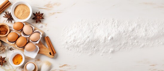 Obraz na płótnie Canvas Flat lay baking background with flour eggs sugar spices and whisk on a white tabletop