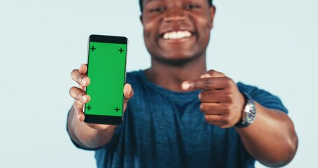 Man, pointing and portrait with green screen for mobile app in studio for fitness, training or online exercise program. Hand, ok sign gesture and athlete with phone for promotion or social media