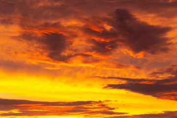 Mystical orange-yellow sky with clouds at sunset. Beauty and passion. Perfect background for your design