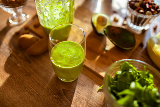 Freshly blended green fruit smoothie in a glass jar on the countertop