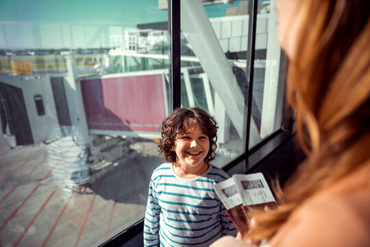 Young mother and son waiting for their flight at the airport