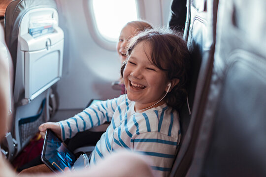 Young boy using a tablet and having fun on his flight