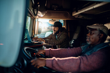 Two diverse truck drivers working together while on the road