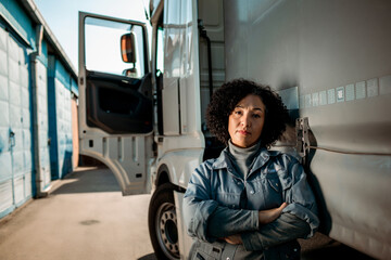Portrait of a confident young female truck driver in front of her vehicle