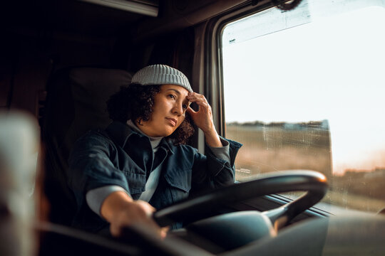 Young female truck driver is getting tired after a long driving session