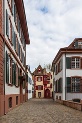 The ancient traditional houses in the cozy downtown of Basel, created in bright colors with mosaic tiles on the roof