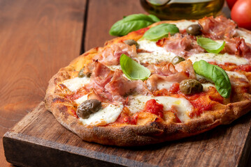 Deliziosa pinsa romana condita con mopzzarella, sugo, olive e prosciutto cotto, cibo italiano 