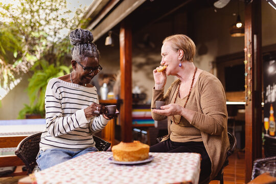 Duas mulheres idosas tomando cafe da manhe, tomando cafe e conversando.