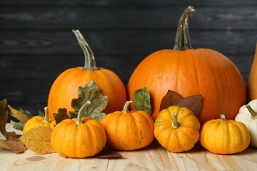 Thanksgiving day. Many different pumpkins and dry leaves on wooden table