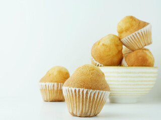 Close up. baked muffin on white background and porcelain bowl.