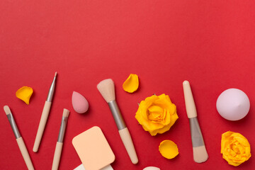 Makeup brushes and sponges on color background, top view
