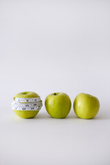 Green apple with white measurement tape