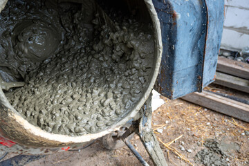 Concrete mixer with pouring cement. Close up on concrete mixer, cement mortar mixing. Preparing...
