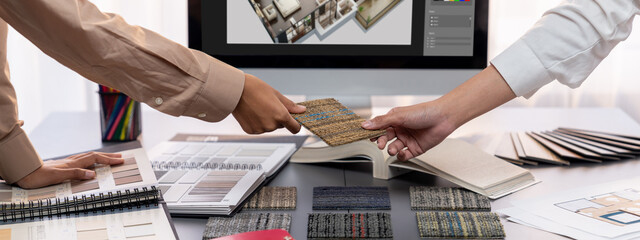 Group of interior architect designer team at table choosing various mood board samples with...