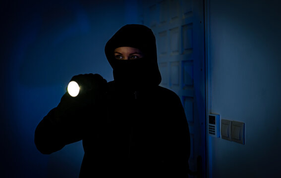 Female thief breaks into the apartment through the front door.